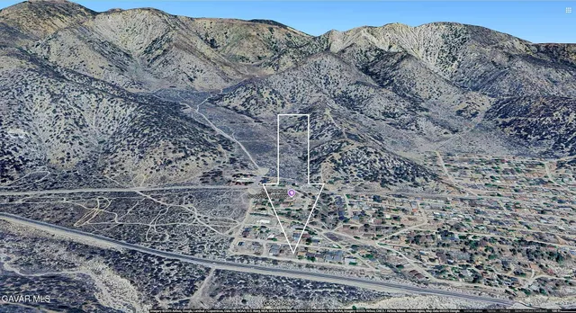 a view of a dry yard with wooden fence