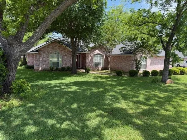a view of a house with a big yard and large tree