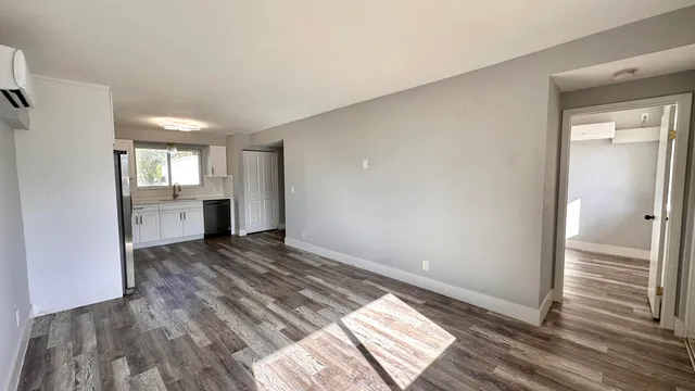 a view of an empty room and window and wooden floor