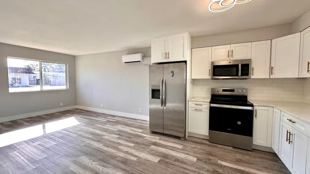 a kitchen with granite countertop a refrigerator and a stove top oven