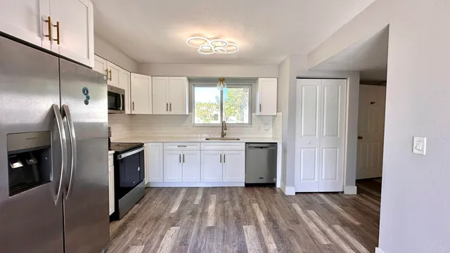 a kitchen with stainless steel appliances granite countertop a refrigerator and a sink