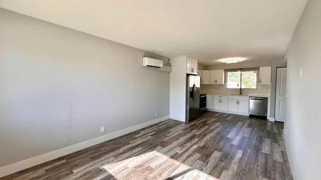 a view of a kitchen with wooden floor and a sink
