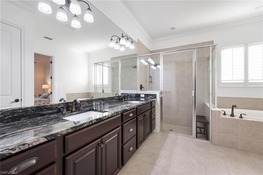 3275 Pilot Circle Naples, FL 34120 - Photo 21 of 44 a bathroom with a granite countertop sink a large mirror and a bathtub