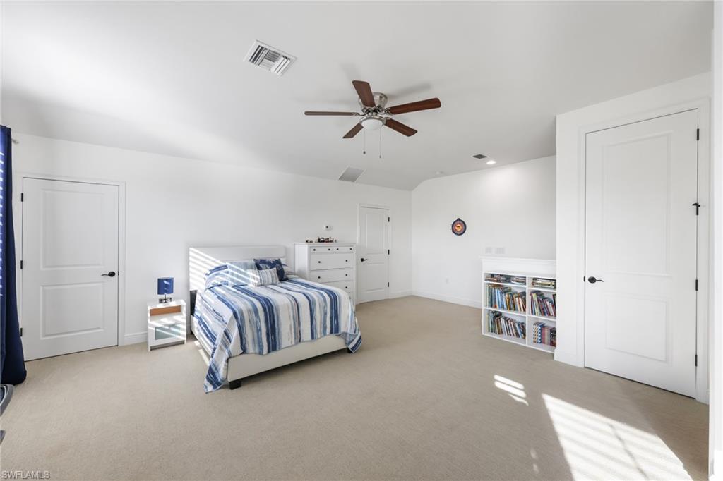 3275 Pilot Circle Naples, FL 34120 - Photo 29 of 44 a spacious bedroom with a bed and a chandelier