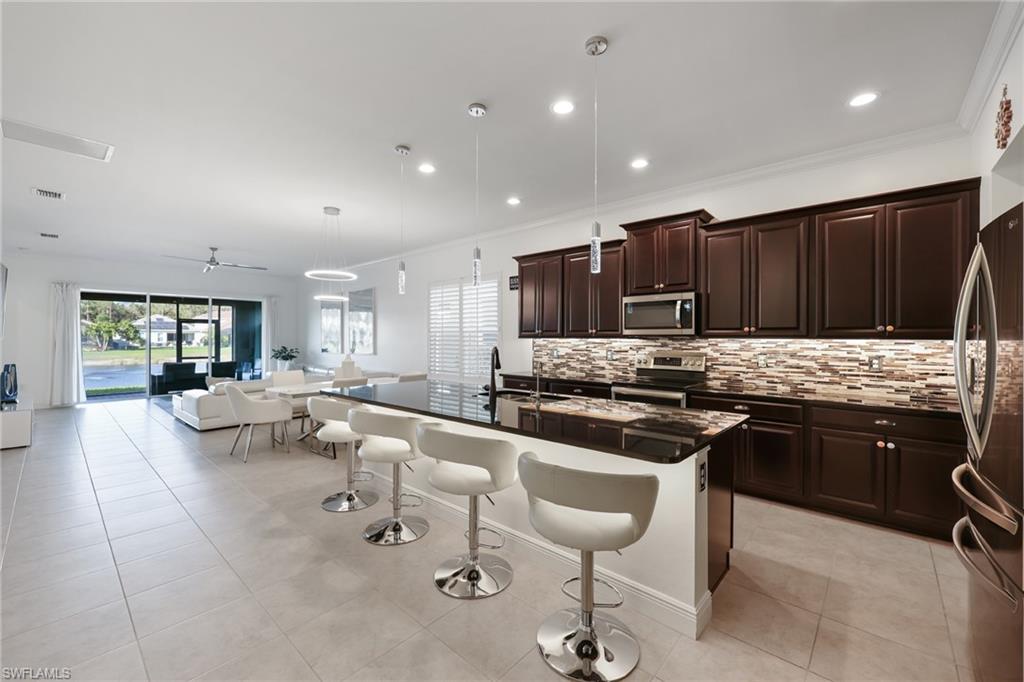 3275 Pilot Circle Naples, FL 34120 - Photo 7 of 44 a kitchen with stainless steel appliances granite countertop a stove and a sink