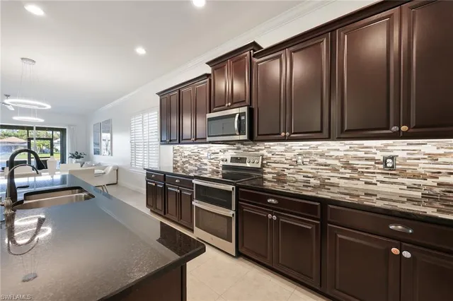 a kitchen with stainless steel appliances granite countertop wooden cabinets a stove top oven a granite counter top and a stove