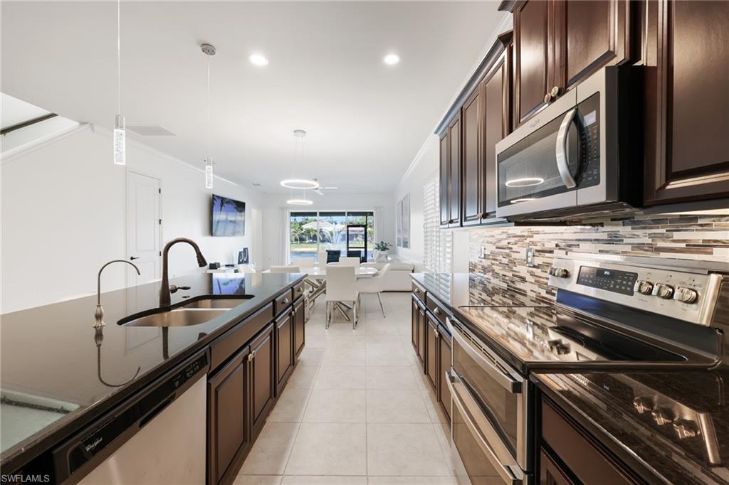 3275 Pilot Circle Naples, FL 34120 - Photo 10 of 44 a kitchen with stainless steel appliances granite countertop a sink and stove