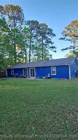 a view of a yard with red door and wooden fence