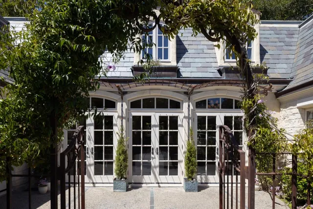 a front view of a house with a tree