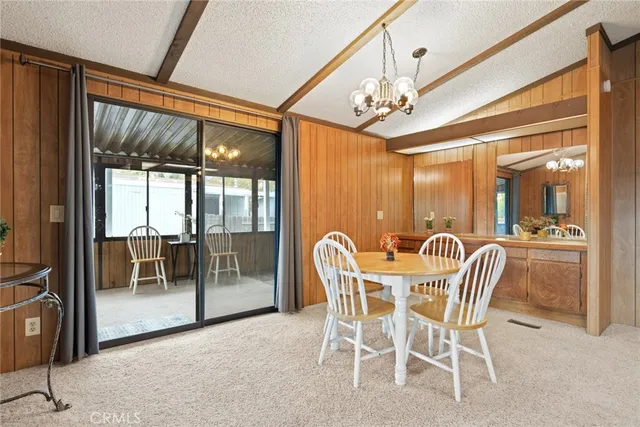 a view of a dining room with furniture a chandelier and window