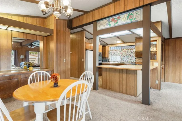 a dining room with furniture a chandelier and wooden floor