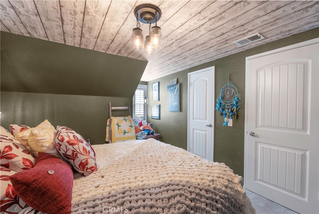 5481 Peacock Lane Riverside, CA 92505 - Photo 34 of 69 a bedroom with a bed and a chandelier