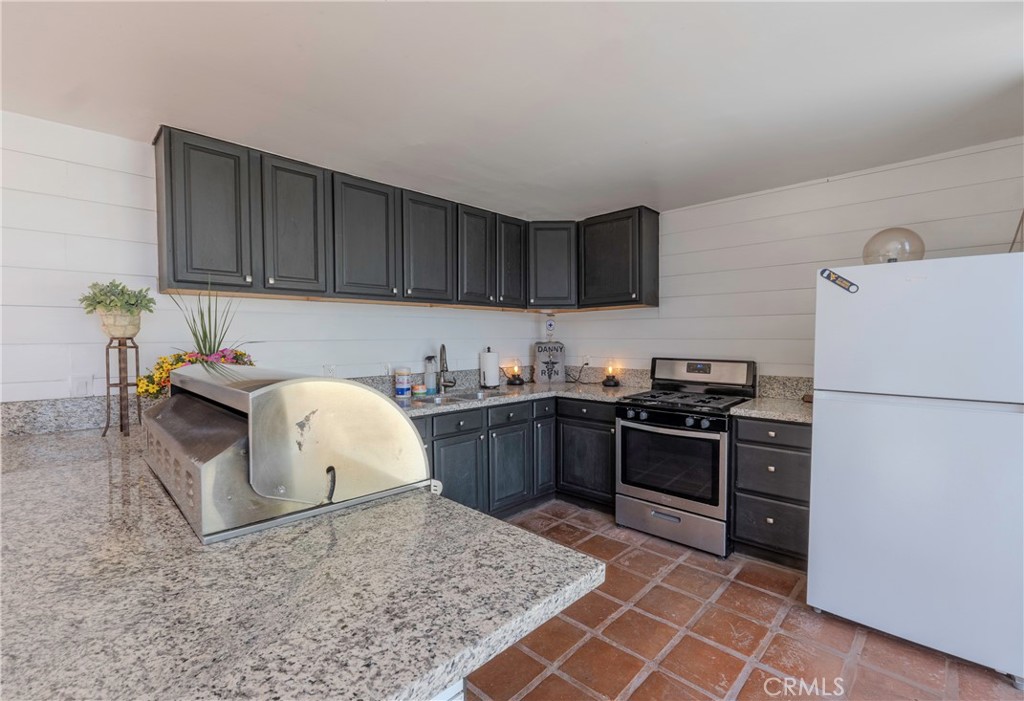5481 Peacock Lane Riverside, CA 92505 - Photo 51 of 69 a kitchen with granite countertop a stove a sink and a refrigerator