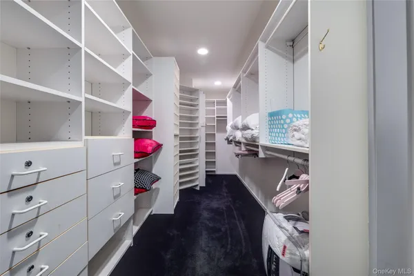 a view of walk in closet with clothes and shoes