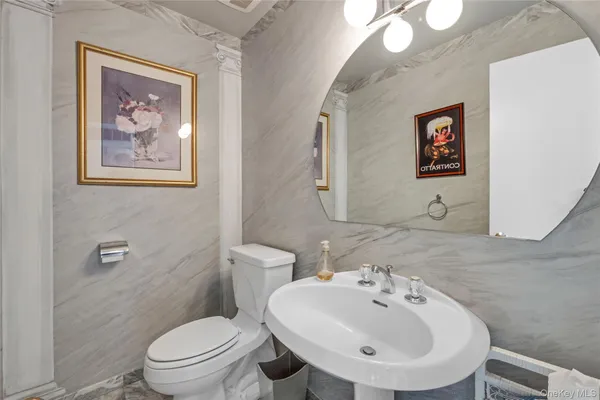 a bathroom with a toilet a sink and mirror