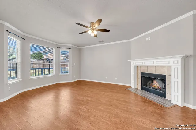 a view of an empty room with exposed radiator and fireplace