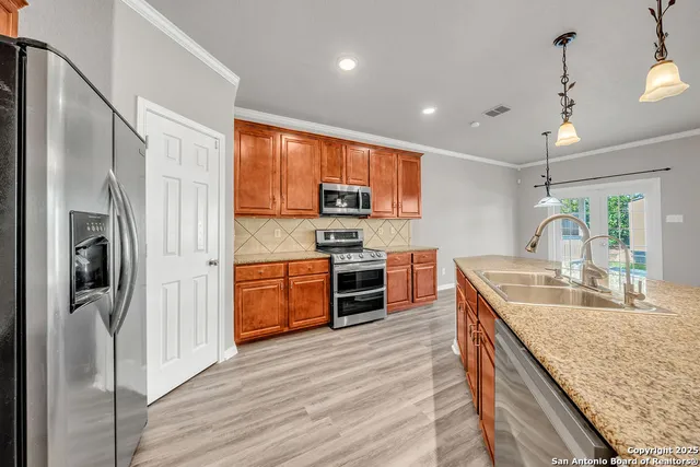 a kitchen with stainless steel appliances granite countertop a refrigerator a stove a sink and a microwave