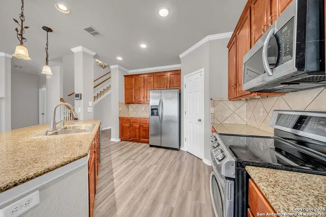 a kitchen with stainless steel appliances granite countertop a sink and a stove