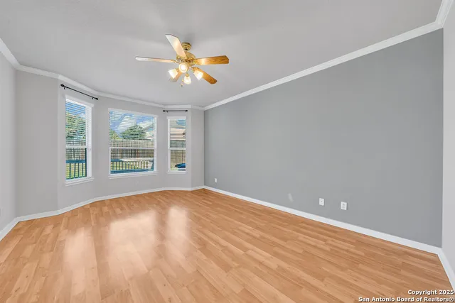 a view of an empty room with window and wooden floor