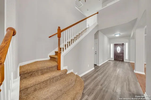 a view of a livingroom with wooden floor and stairs