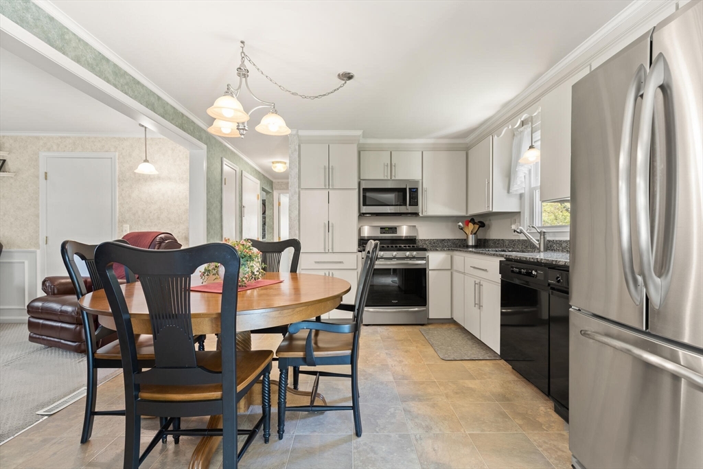 25 Bellflower Road Billerica, MA 01821 - Photo 13 of 40 a kitchen with stainless steel appliances granite countertop a dining table chairs refrigerator and microwave