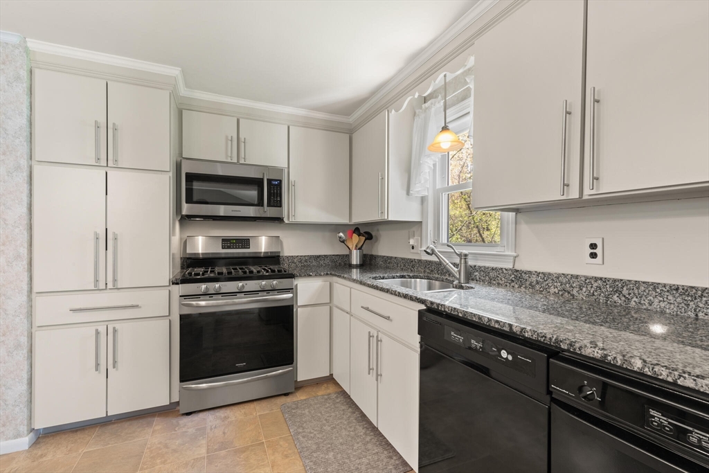 25 Bellflower Road Billerica, MA 01821 - Photo 15 of 40 a kitchen with stainless steel appliances granite countertop a stove a sink and a microwave
