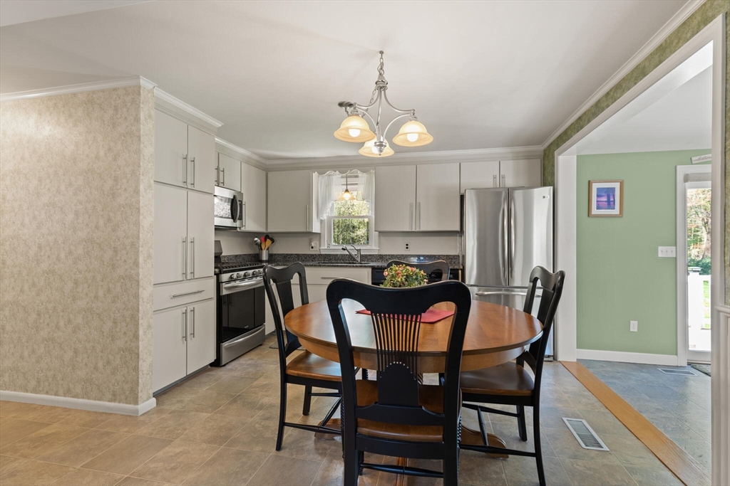 25 Bellflower Road Billerica, MA 01821 - Photo 16 of 40 a kitchen with refrigerator a dining table and chairs