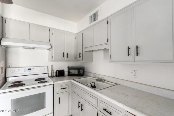 a kitchen with white cabinets and white appliances