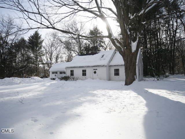 a view of a white house with a yard covered in snow