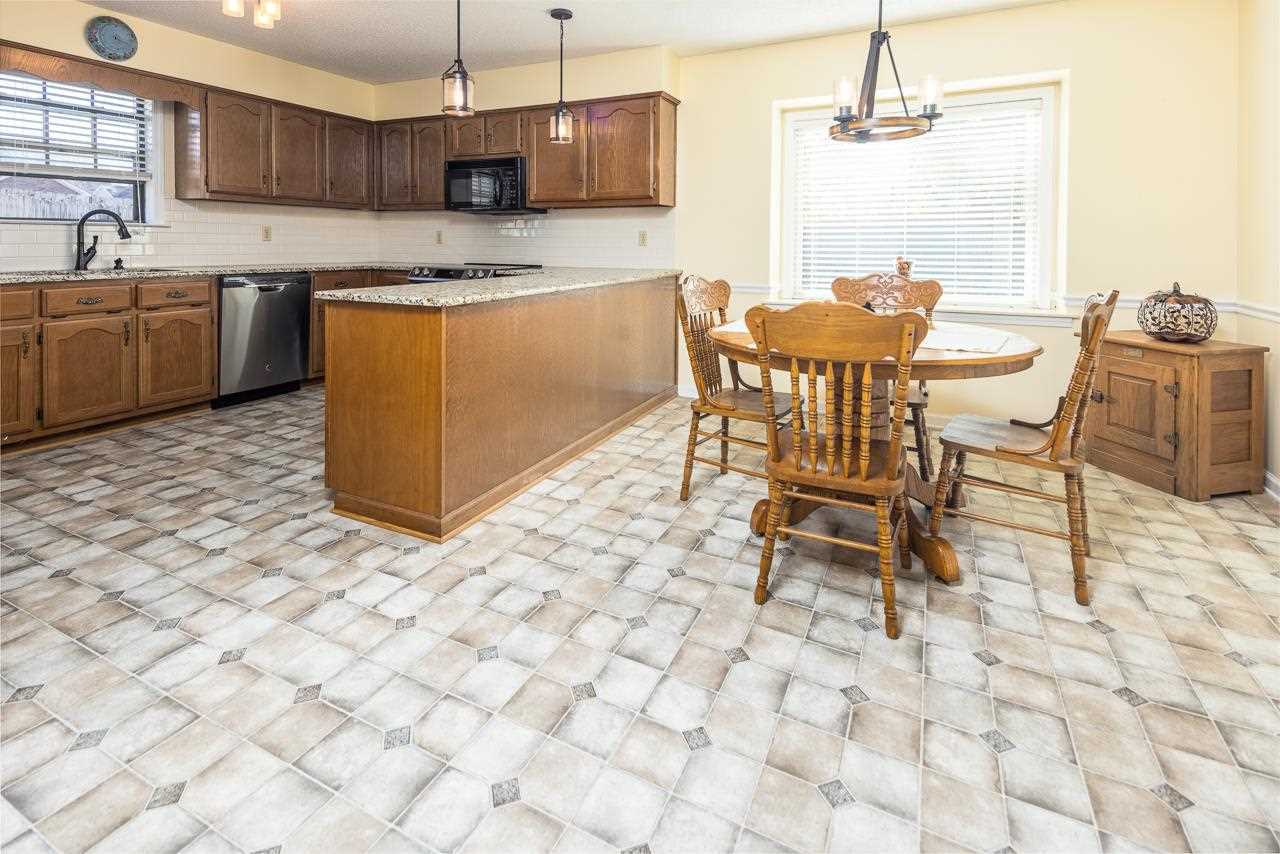 297 East White Road Collierville, TN 38017 - Photo 6 of 20 a kitchen with stainless steel appliances granite countertop a sink a stove a dining table and chairs
