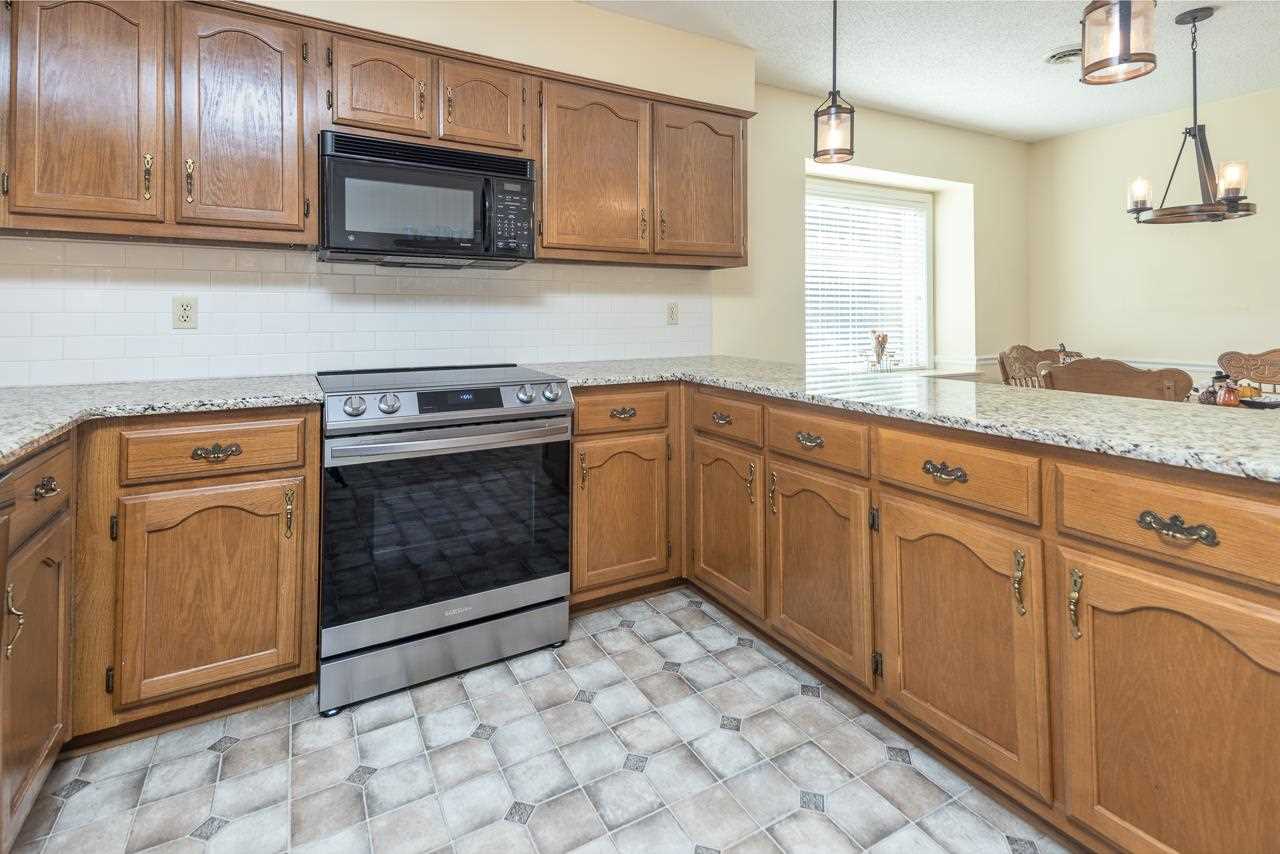 297 East White Road Collierville, TN 38017 - Photo 9 of 20 a kitchen with granite countertop a stove microwave and sink