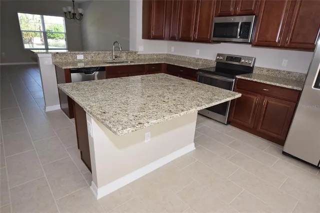 a kitchen with stainless steel appliances granite countertop a sink stove and microwave