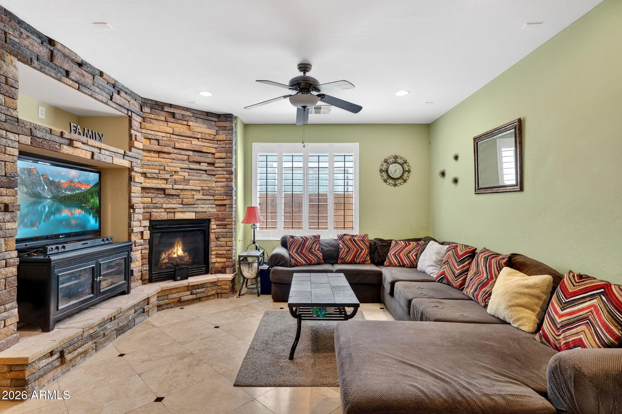 1729 South Reseda Street Gilbert, AZ 85295 - Photo 11 of 52 a living room with furniture a fireplace and a flat screen tv