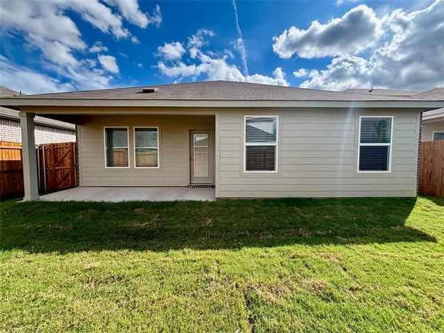 a view of a backyard with plants and large tree