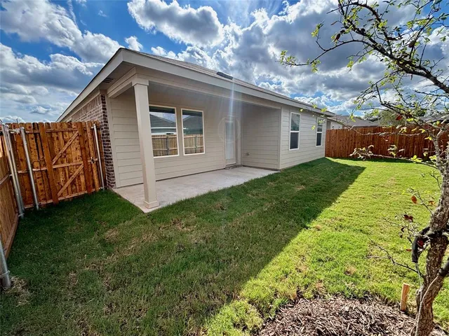 a view of a house with a small yard and a garden