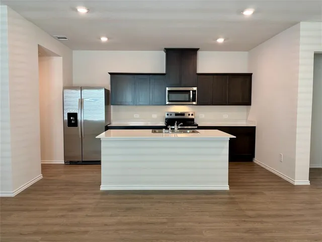 a view of kitchen with stainless steel appliances a sink and a refrigerator