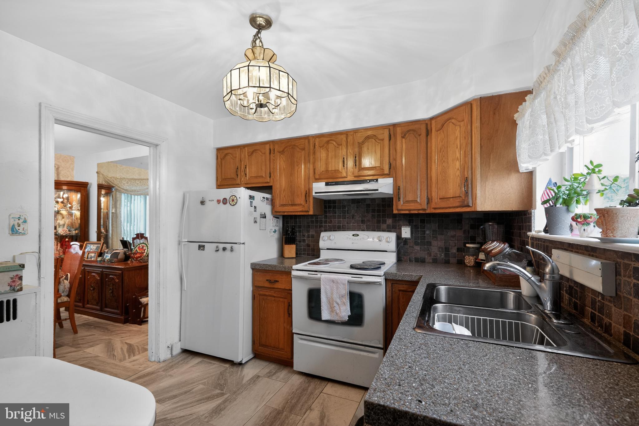 1424 Burmont Road Havertown, PA 19083 - Photo 9 of 37 a kitchen with stainless steel appliances granite countertop a stove a sink dishwasher and a refrigerator with wooden floor