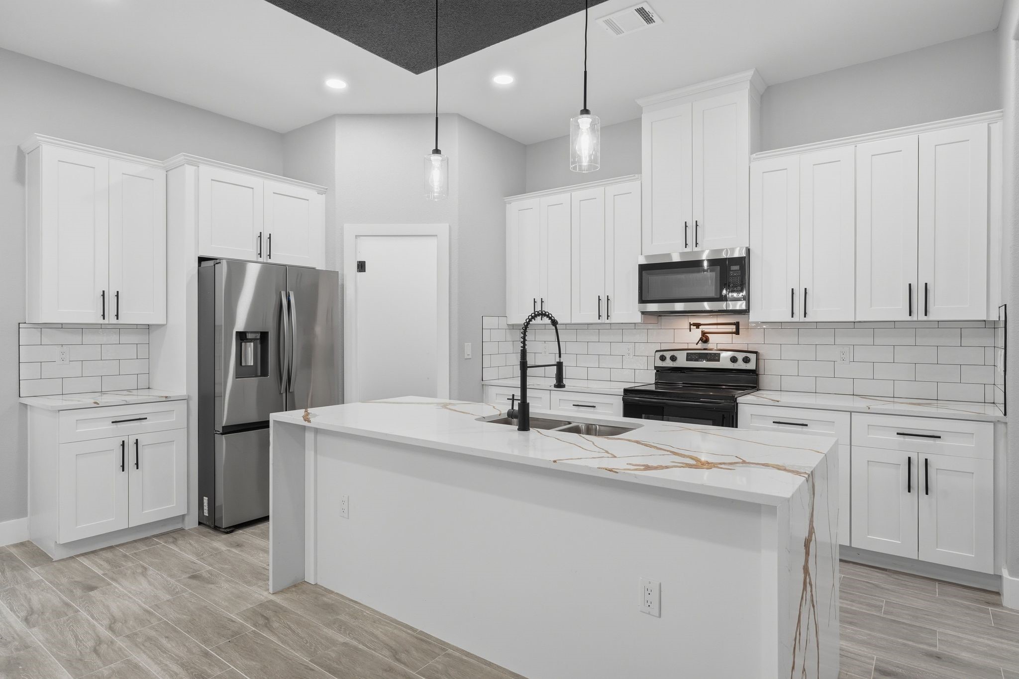 3575 Roy Bean Road Willis, TX 77378 - Photo 15 of 40 a kitchen with kitchen island a refrigerator sink and white cabinets