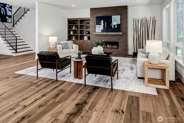 a living room with furniture kitchen view and large windows