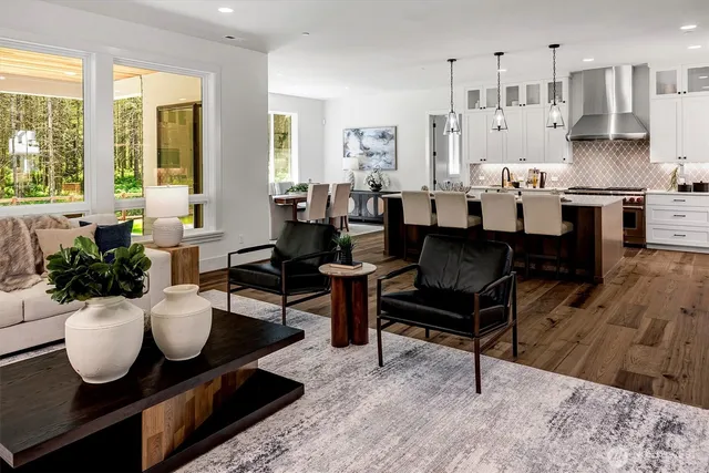 a kitchen with stainless steel appliances a dining table chairs stove and sink