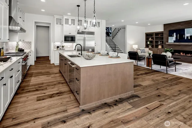 a kitchen with stainless steel appliances a dining table chairs a sink and dishwasher