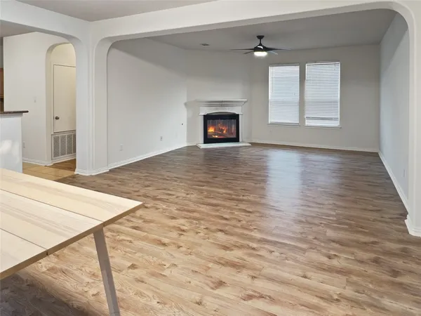 an empty room with windows and fireplace