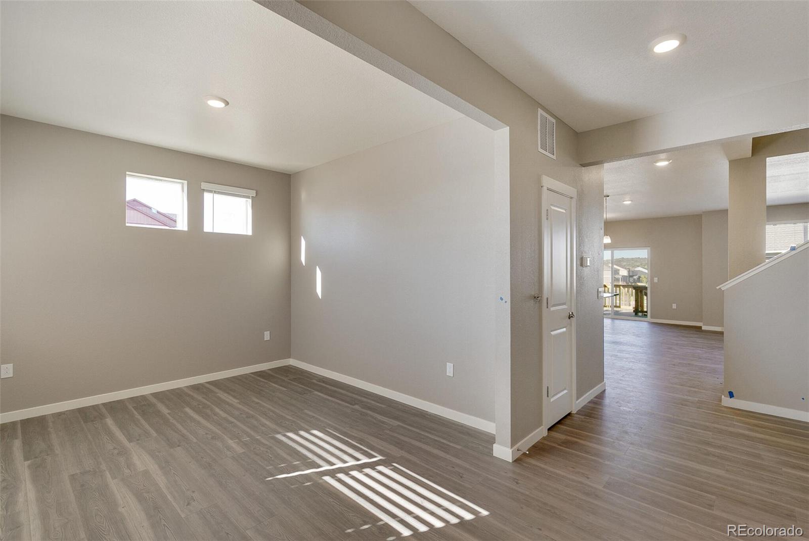 18358 Field Mint Point Parker, CO 80134 - Photo 4 of 34 a view of a hallway with wooden floor and a living room