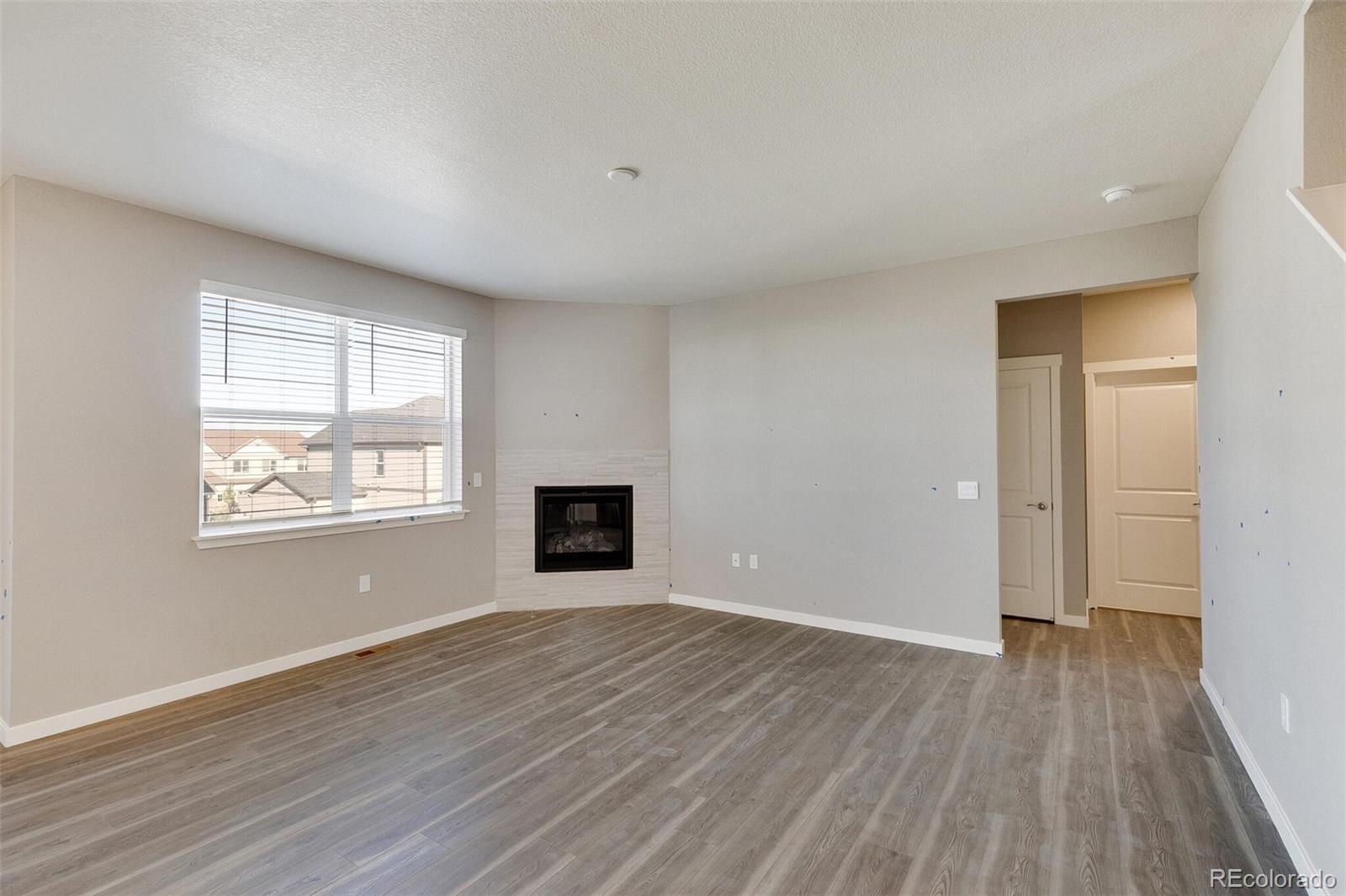 18358 Field Mint Point Parker, CO 80134 - Photo 9 of 34 a view of an empty room with wooden floor and a window