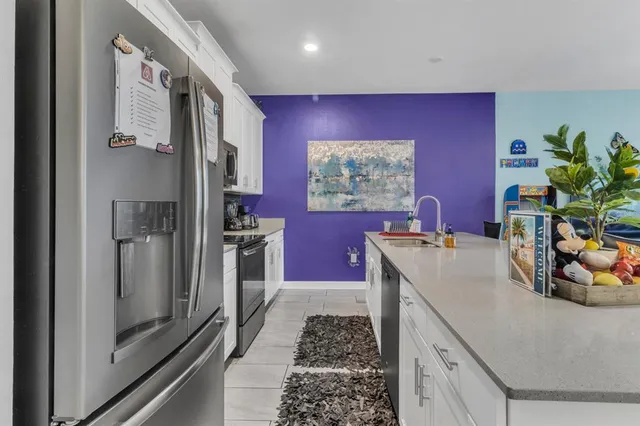 a kitchen with stainless steel appliances granite countertop a refrigerator and a sink