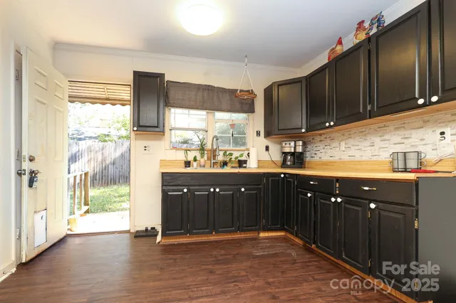 a kitchen with stainless steel appliances granite countertop a refrigerator a sink dishwasher and wooden cabinets with wooden floor