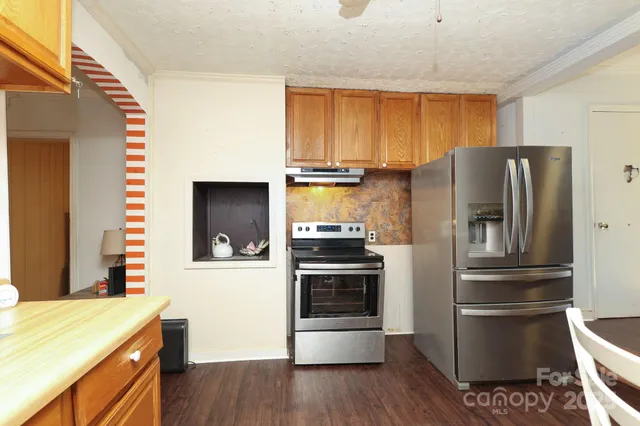 a kitchen with granite countertop stainless steel appliances and wooden cabinets