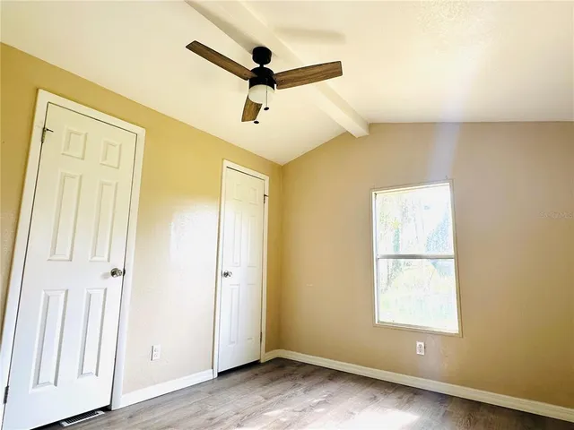 a view of a livingroom with a window and wooden floor