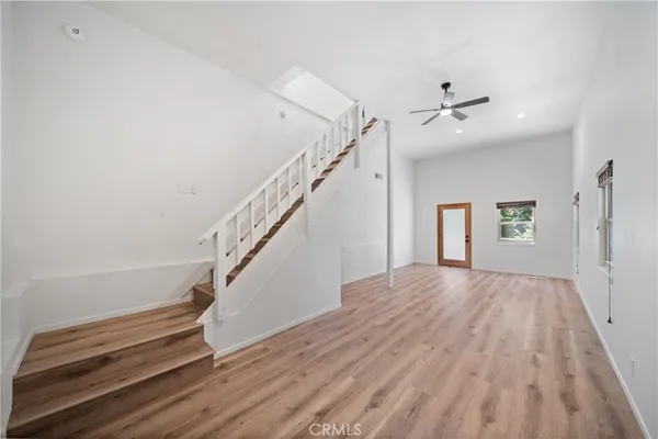 a view of a livingroom with wooden floor and stairs