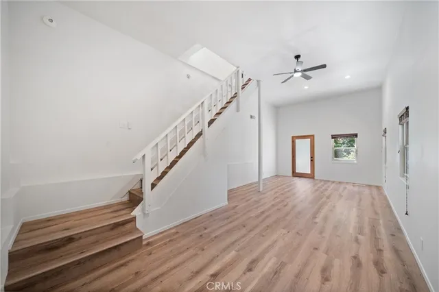 a view of a livingroom with wooden floor and stairs